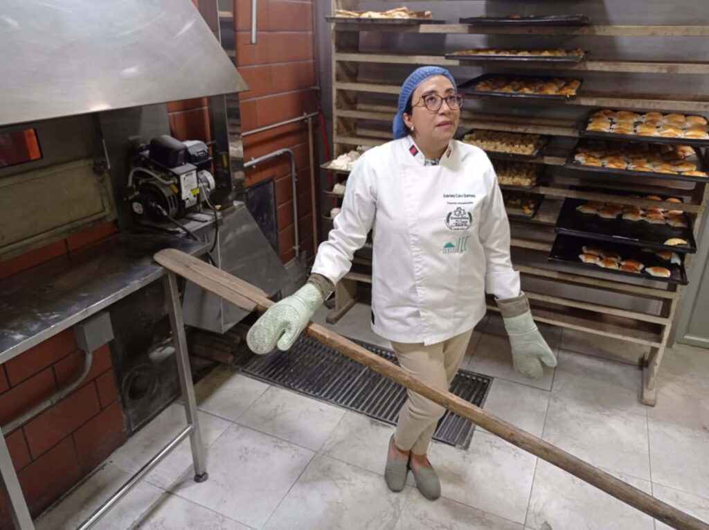Gabriela Cobo junto al horno de ladrillo refractario con el que cuenta el establecimiento. (Javier Tamba)